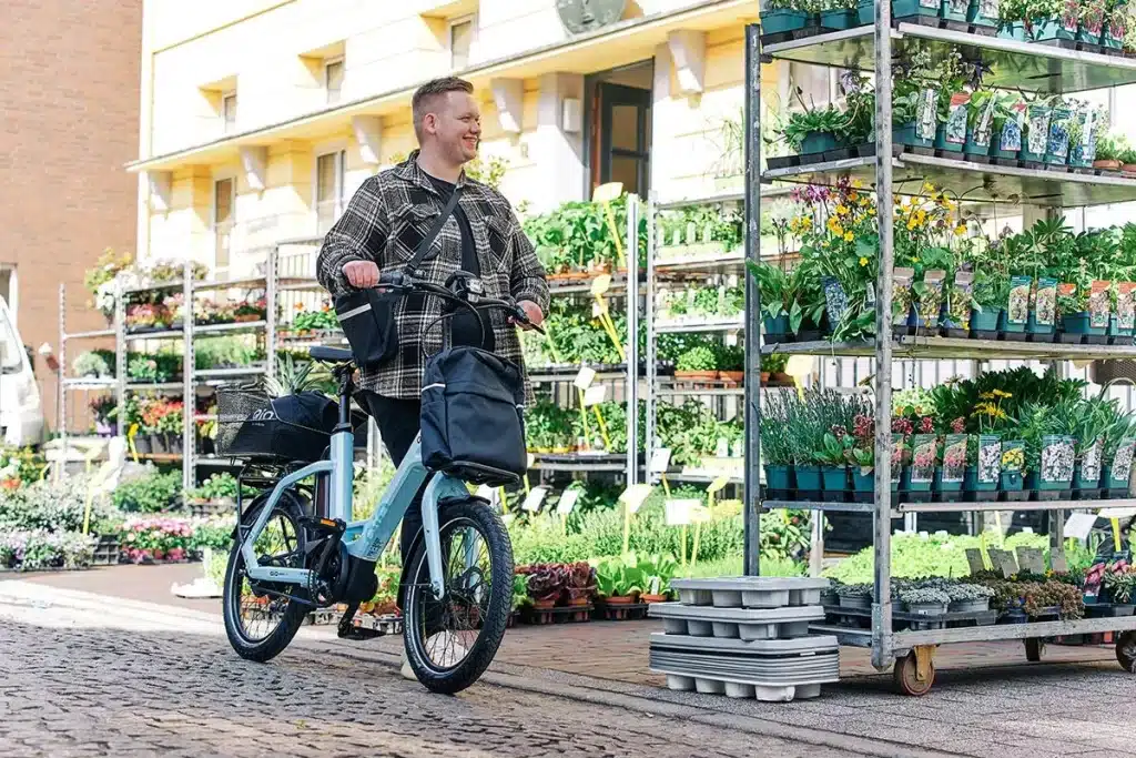 qio-eins-plus-mann-vor-blumenstand