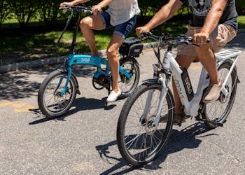 Ein Paar genießt an einem sonnigen Tag in Patchogue, New York, eine Fahrt auf Elektrofahrrädern.