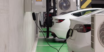 Electric vehicles charging at an indoor station in a modern underground garage.