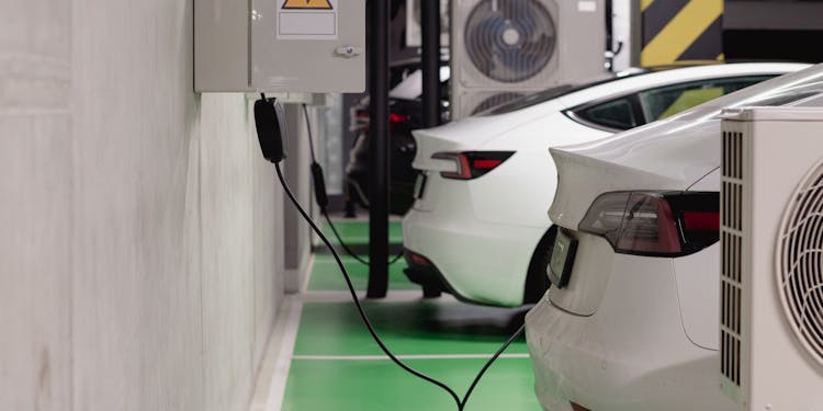 Electric vehicles charging at an indoor station in a modern underground garage.