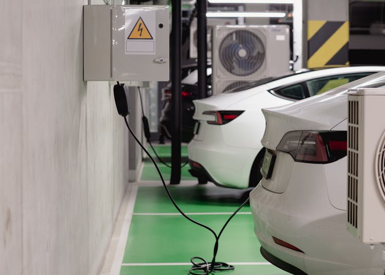 Electric vehicles charging at an indoor station in a modern underground garage.