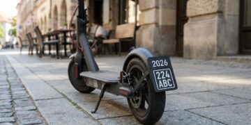E-Scooter mit neuem schwarzen Versicherungskennzeichen 2026 auf einem Gehweg
