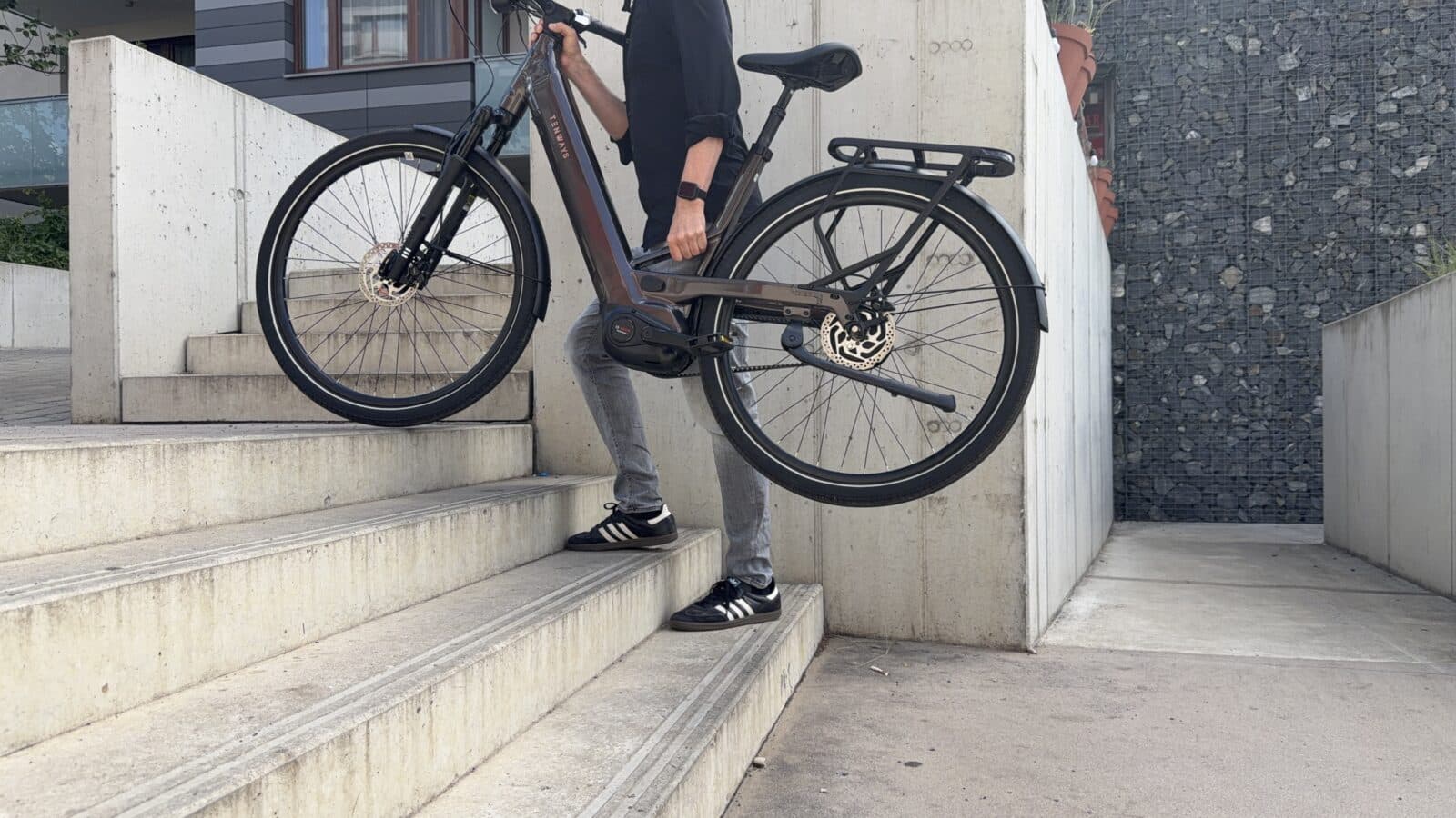 E-Bike wird über eine Treppe getragen
