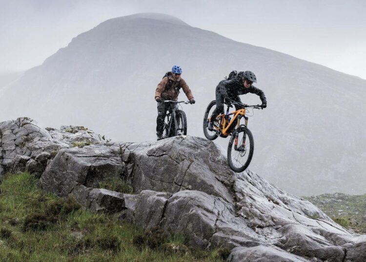 Zwei Mountainbiker auf einem Felsen im Gebirge, Symbolbild der Marke Haibike