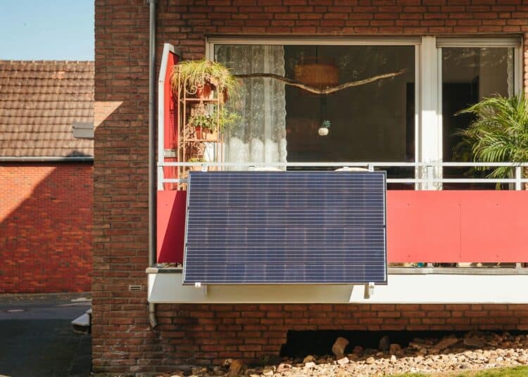 Ein Solarmodul hängt an einem Balkon im Erdgeschoss.
