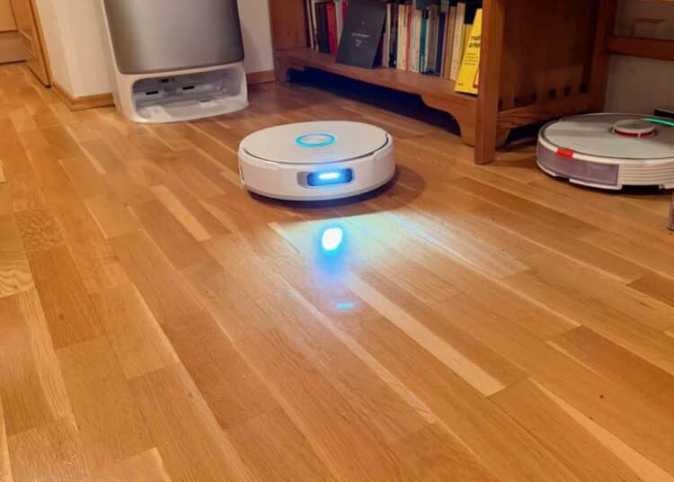 Saug-Wischroboter Narwal Flow auf Parkett, dahinter ein älterer Roborock S7