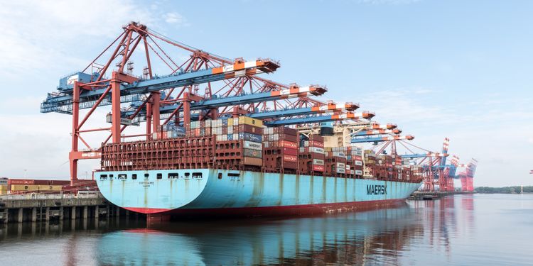 Überrollt China den europäischen E-Bike-Markt? Fahrradbranche fordert weitere Schutzzölle A large container ship docked at the Port of Hamburg with cranes loading cargo.